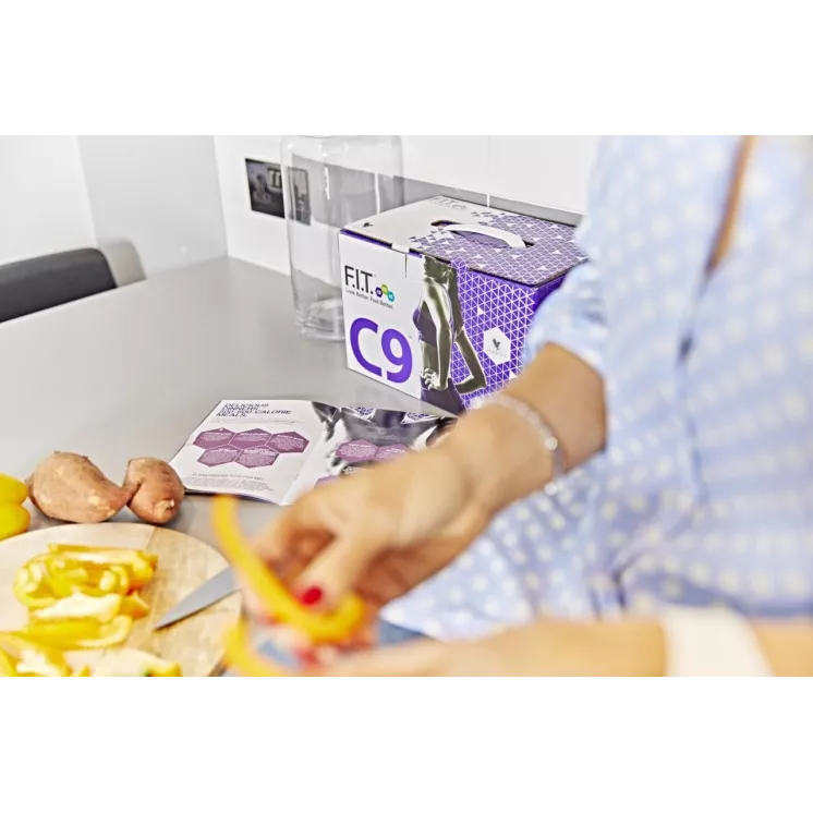 Préparation de repas sains pendant la cure Forever C9 avec le pack détox visible en arrière-plan sur un plan de travail