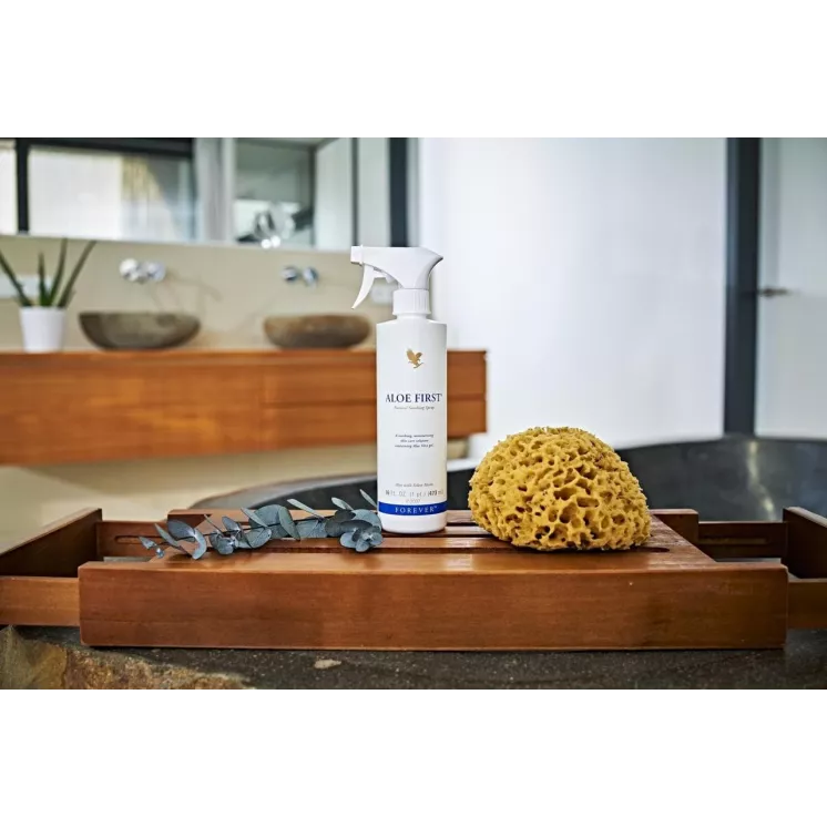 Spray Forever Aloe First, présenté dans une salle de bain avec éponge naturelle, hydratant et apaisant à l'Aloe Vera et propolis