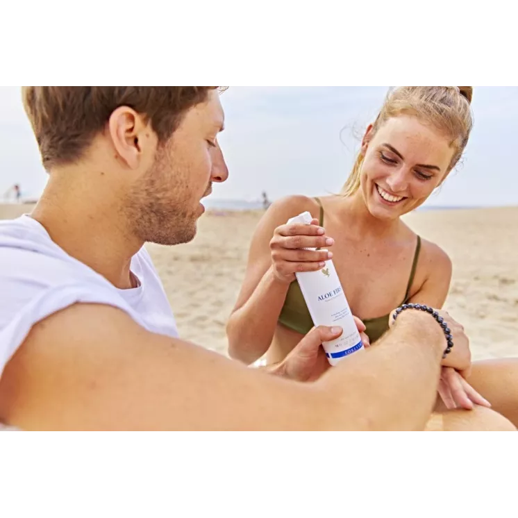 Couple appliquant le spray Forever Aloe First sur la peau en extérieur pour apaiser et hydrater après une exposition au soleil