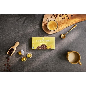 Arrangement élégant de Forever MÓR avec tasse d'espresso, capsules dorées et boîte de café fonctionnel sur un plan de travail