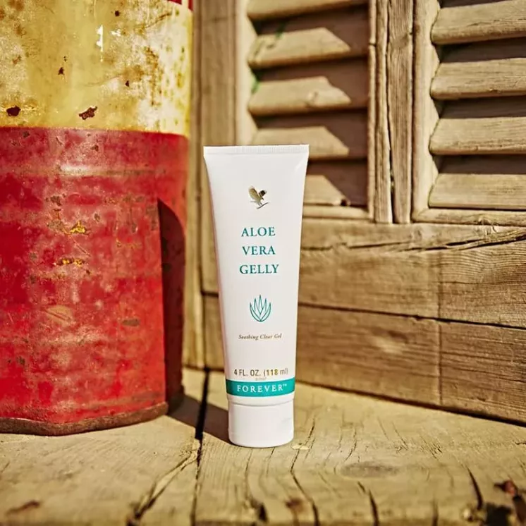Tube de Forever Aloe Vera Gelly posé en extérieur, sur un fond bois et métal rustique.
