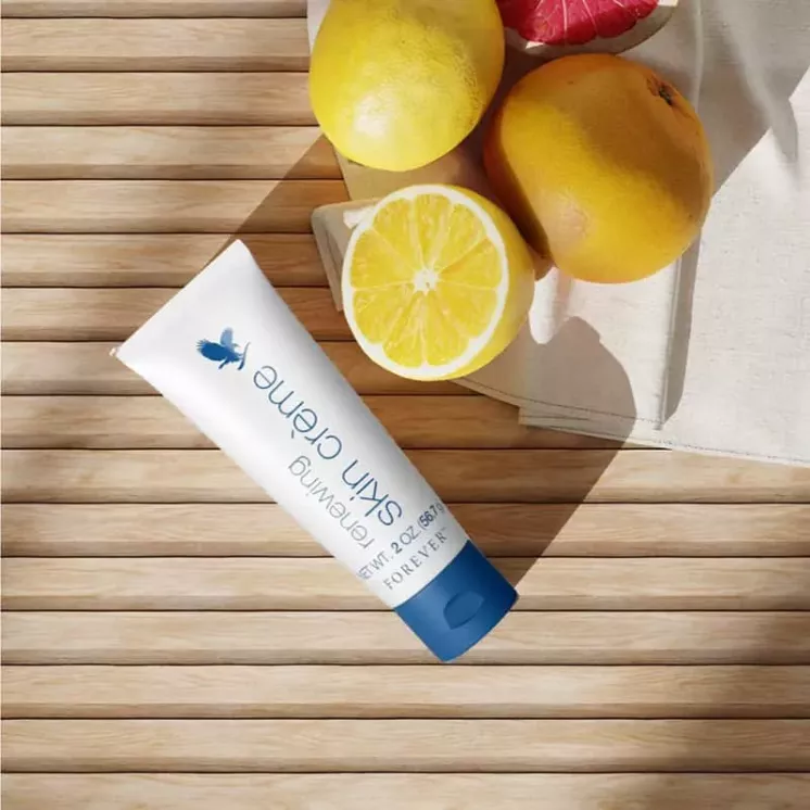 Crème Régénératrice Forever Renewing Skin Crème avec Aloe Vera et AHA, mise en scène avec agrumes.