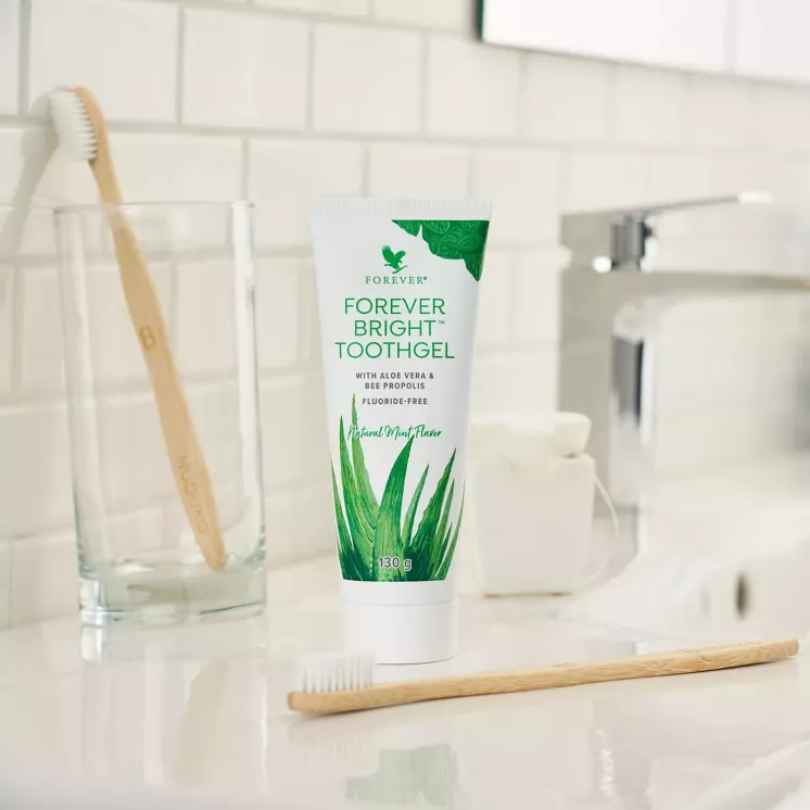Dentifrice aloe vera Forever Bright Toothgel posé sur lavabo avec brosse à dents en salle de bain