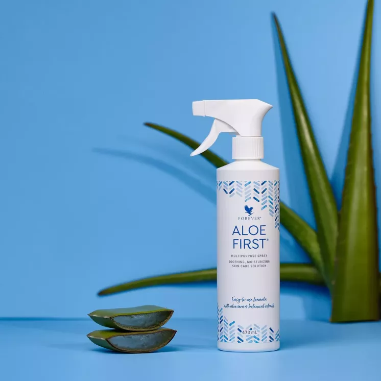 Forever Aloe First posé au milieu de feuilles d’aloe vera coupées