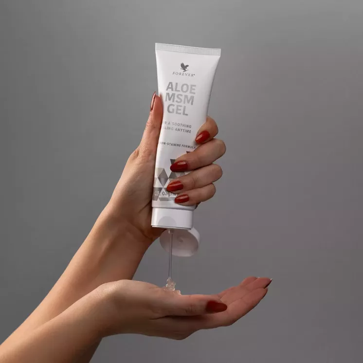 Tube d’Aloe MSM Gel tenu au-dessus d’une main pour doser le produit