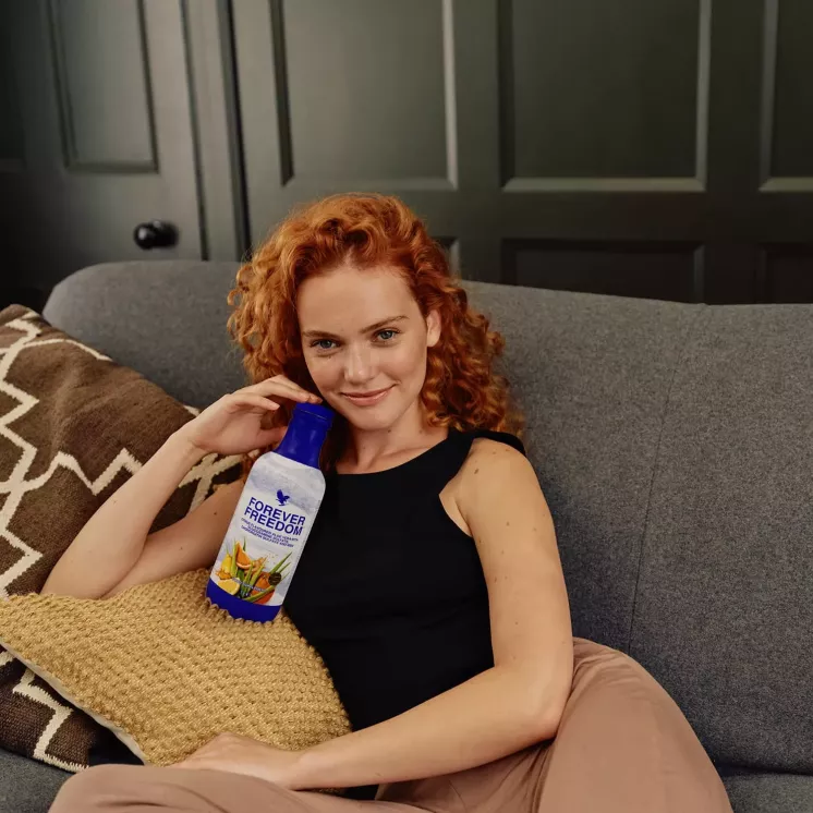 Femme assise tenant une bouteille de Forever Freedom